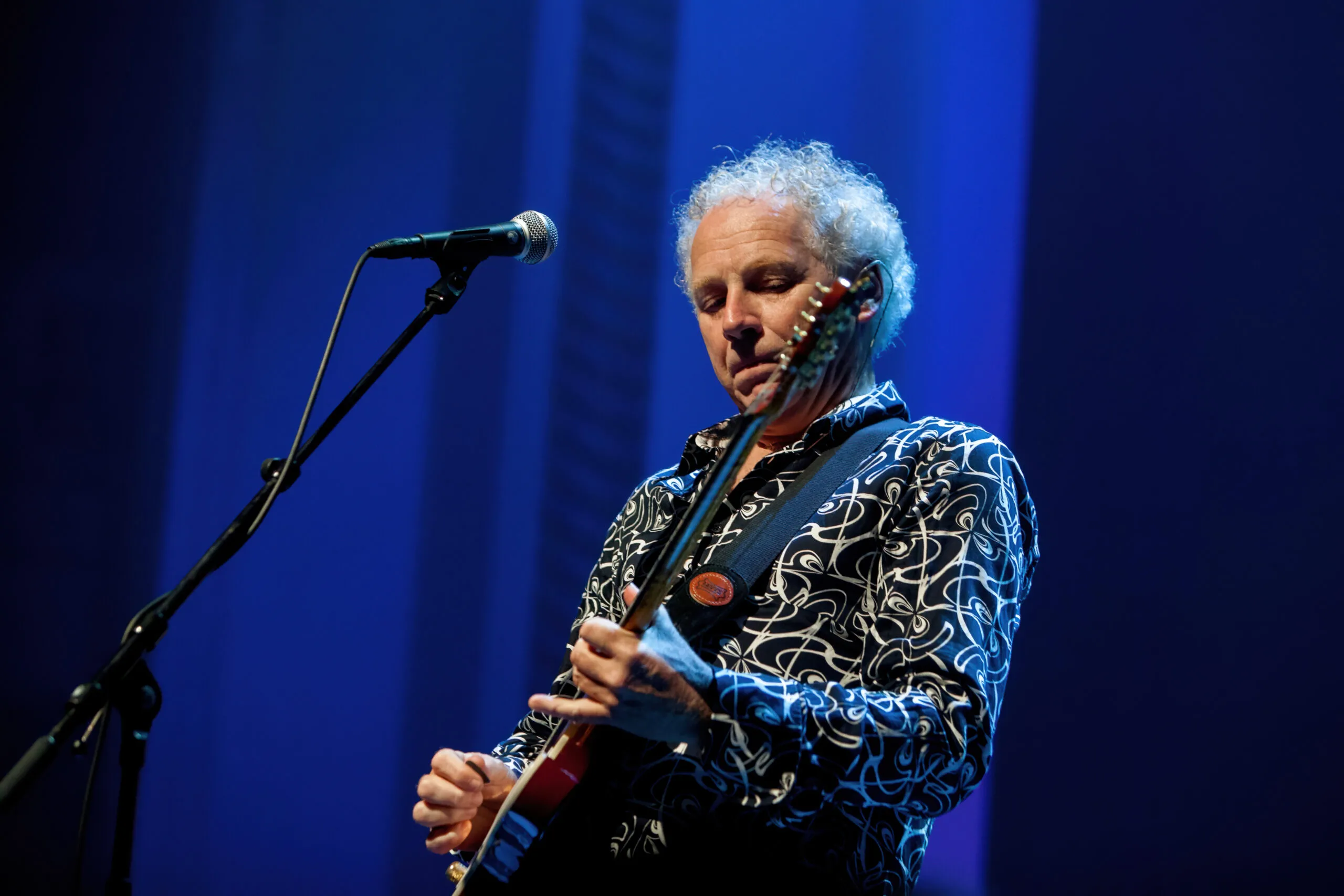 Jan Hendriks op zijn gitaar tijdens concert.